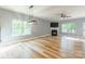 Bright living room featuring large windows, a ceiling fan, and a cozy fireplace at 2202 Chickasaw Loop, Rock Hill, SC 29732