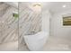 Luxurious bathroom featuring marble accents, a standalone tub, a chandelier and a glass-enclosed shower at 2411 Ainsdale Rd, Charlotte, NC 28226