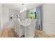 Bright dining room with white table set, chandelier and blue curtains overlooking landscaped yard at 2411 Ainsdale Rd, Charlotte, NC 28226