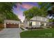 Stunning two-story home with beautiful landscaping, an attached garage and a classic brick and siding facade at 2411 Ainsdale Rd, Charlotte, NC 28226