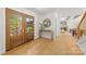 Bright foyer showcasing hardwood floors, double doors, and a decorative table beneath a circular mirror at 2411 Ainsdale Rd, Charlotte, NC 28226