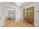 Inviting foyer featuring hardwood floors, a modern chandelier, and natural light flowing into the dining room at 2411 Ainsdale Rd, Charlotte, NC 28226