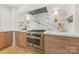 Gourmet kitchen showcasing stainless steel oven, marble backsplash, and custom cabinetry at 2411 Ainsdale Rd, Charlotte, NC 28226