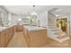 Bright open kitchen with island, counter seating, stainless appliances, and view to the staircase at 2411 Ainsdale Rd, Charlotte, NC 28226