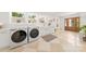Well-lit laundry room with modern washer, dryer, stylish cabinets and a farmhouse sink at 2411 Ainsdale Rd, Charlotte, NC 28226
