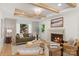 Bright living room features a stone fireplace, beamed ceiling, and comfortable seating with lots of natural light at 2411 Ainsdale Rd, Charlotte, NC 28226