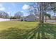 Extensive green backyard, enclosed with a white fence, backs the house, and has a variety of trees at 247 Timberland Loop, Mooresville, NC 28115