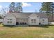 Spacious backyard with a patio, barbecue, and outdoor seating adjacent to the single-story house at 247 Timberland Loop, Mooresville, NC 28115
