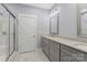 Bathroom featuring glass door shower, double vanity with granite countertop, and gray cabinetry at 247 Timberland Loop, Mooresville, NC 28115