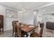 Dining room with wooden table and seating, wainscoting, stylish lighting, and view to the living space at 247 Timberland Loop, Mooresville, NC 28115