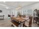 Open-concept dining area features a wooden table, bench seating, and modern light fixture at 247 Timberland Loop, Mooresville, NC 28115