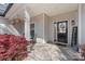 Inviting covered front porch with decorative plants and a welcoming black front door with sidelights at 247 Timberland Loop, Mooresville, NC 28115