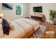 Cozy bedroom with a comfortable bed, modern dresser, TV, and a serene window view at 249 Arrowood Ave, Lancaster, SC 29720