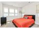 Comfortable bedroom featuring large windows, neutral tones, and a bed with an orange comforter at 2520 Ensemble Ct, Charlotte, NC 28262