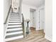 Bright entryway featuring wood floors, white stairs, and modern decor creating a welcoming space at 2520 Ensemble Ct, Charlotte, NC 28262