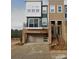 Modern townhome showcases mixed material facade, balcony, and convenient attached two-car garage at 2520 Ensemble Ct, Charlotte, NC 28262