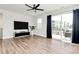 Spacious living room with hardwood floors, TV, and sliding glass doors to a balcony with natural light at 2520 Ensemble Ct, Charlotte, NC 28262