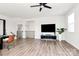 Open-concept living room with hardwood floors, TV and balcony with a modern ceiling fan at 2520 Ensemble Ct, Charlotte, NC 28262