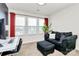 Comfortable living room with a plush sofa, ottoman, and large windows providing ample light at 2520 Ensemble Ct, Charlotte, NC 28262