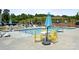 Community pool area with lounge chairs, tables with umbrellas, and a splash area for  at 2520 Ensemble Ct, Charlotte, NC 28262