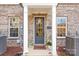 Charming brick home entrance with decorative columns, a gray front door and a 'welcome' mat at 2558 Deacon Ave, Charlotte, NC 28204