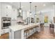 Bright kitchen features a large island with bar stool seating, modern appliances, and white cabinetry at 2558 Deacon Ave, Charlotte, NC 28204
