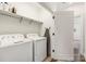 Well-organized laundry room with front load washer and dryer, shelving, and door to living area at 2558 Deacon Ave, Charlotte, NC 28204