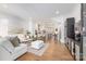 Sunlit living room with hardwood floors leads into a modern kitchen, creating a welcoming and open space at 2558 Deacon Ave, Charlotte, NC 28204