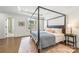 Main bedroom features hardwood floors, a four poster bed and en suite bathroom access at 2558 Deacon Ave, Charlotte, NC 28204