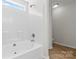 Bright bathroom featuring a tub with white tile surround and natural light from the window at 2708 N Valley Ct, Charlotte, NC 28273