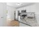 Well-lit kitchen with stainless steel appliances, granite countertops, white cabinets, and tile backsplash at 2708 N Valley Ct, Charlotte, NC 28273
