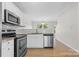 Well-equipped kitchen with stainless steel appliances, granite countertops, white cabinets, and a tile backsplash at 2708 N Valley Ct, Charlotte, NC 28273