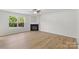 Bright and airy living room featuring wood flooring, a cozy fireplace, and plenty of natural light from the large windows at 2708 N Valley Ct, Charlotte, NC 28273
