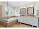 Bright bathroom featuring a soaking tub, double vanity with granite countertop, and natural light through plantation shutters at 2710 Providence Spring Ln, Charlotte, NC 28270