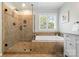 Bathroom featuring a glass-enclosed shower and separate soaking tub with a large window at 2710 Providence Spring Ln, Charlotte, NC 28270