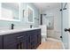 Bathroom featuring a walk-in shower, double vanity with backlit mirrors, and modern fixtures at 2710 Providence Spring Ln, Charlotte, NC 28270