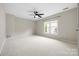 Spacious carpeted bedroom with a ceiling fan and a large window at 2710 Providence Spring Ln, Charlotte, NC 28270