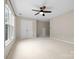Spacious carpeted bedroom with a ceiling fan and a large double door closet at 2710 Providence Spring Ln, Charlotte, NC 28270