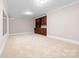 Large bonus room with neutral carpet, built-in cabinets, and ample space for activities at 2710 Providence Spring Ln, Charlotte, NC 28270