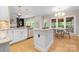Bright kitchen with granite counters, a stainless dishwasher, an island, and an adjacent breakfast nook overlooking the patio at 2710 Providence Spring Ln, Charlotte, NC 28270