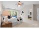 Bright main bedroom offering plush carpet, large windows, and a view into the stylishly appointed bathroom at 2710 Providence Spring Ln, Charlotte, NC 28270