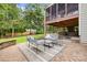 Outdoor patio with comfortable seating, brick pavers, and a serene view of the yard at 2710 Providence Spring Ln, Charlotte, NC 28270