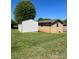 View of back yard featuring the main home and a separate storage building at 28344 Canton Rd, Albemarle, NC 28001