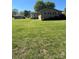 Large backyard with mature trees and grass leading up to a brick home at 28344 Canton Rd, Albemarle, NC 28001