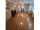 Bright living room with hardwood floors, fireplace, and large windows with curtains at 28344 Canton Rd, Albemarle, NC 28001
