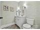 Charming half bathroom with stylish wallpaper, decorative mirrors, and patterned tile flooring at 29268 Pennington Rd, Albemarle, NC 28001