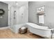 Bright bathroom features a glass shower, stylish soaking tub, and modern fixtures on wood-look flooring at 29268 Pennington Rd, Albemarle, NC 28001