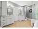 Elegant bathroom featuring double sinks, a glass shower, and neutral finishes on wood-look tile floors at 29268 Pennington Rd, Albemarle, NC 28001