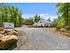 Long gravel driveway leading to a beautifully maintained farmhouse with a barn and storage building at 29268 Pennington Rd, Albemarle, NC 28001