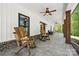 Spacious covered porch with rocking chairs, ceiling fans, and views of the lush surrounding landscape at 29268 Pennington Rd, Albemarle, NC 28001
